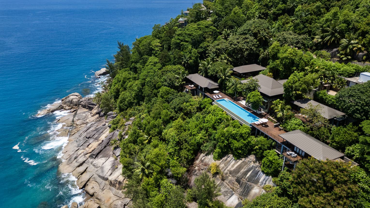 Large private villa on a lush cliff overlooking the sea in tropical location