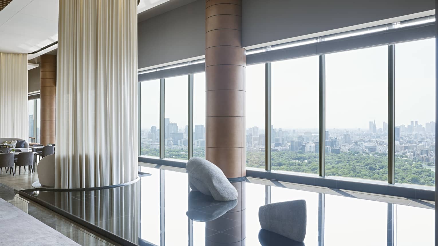 Hotel lounge featuring a calming indoor pond installation and wall of windows 