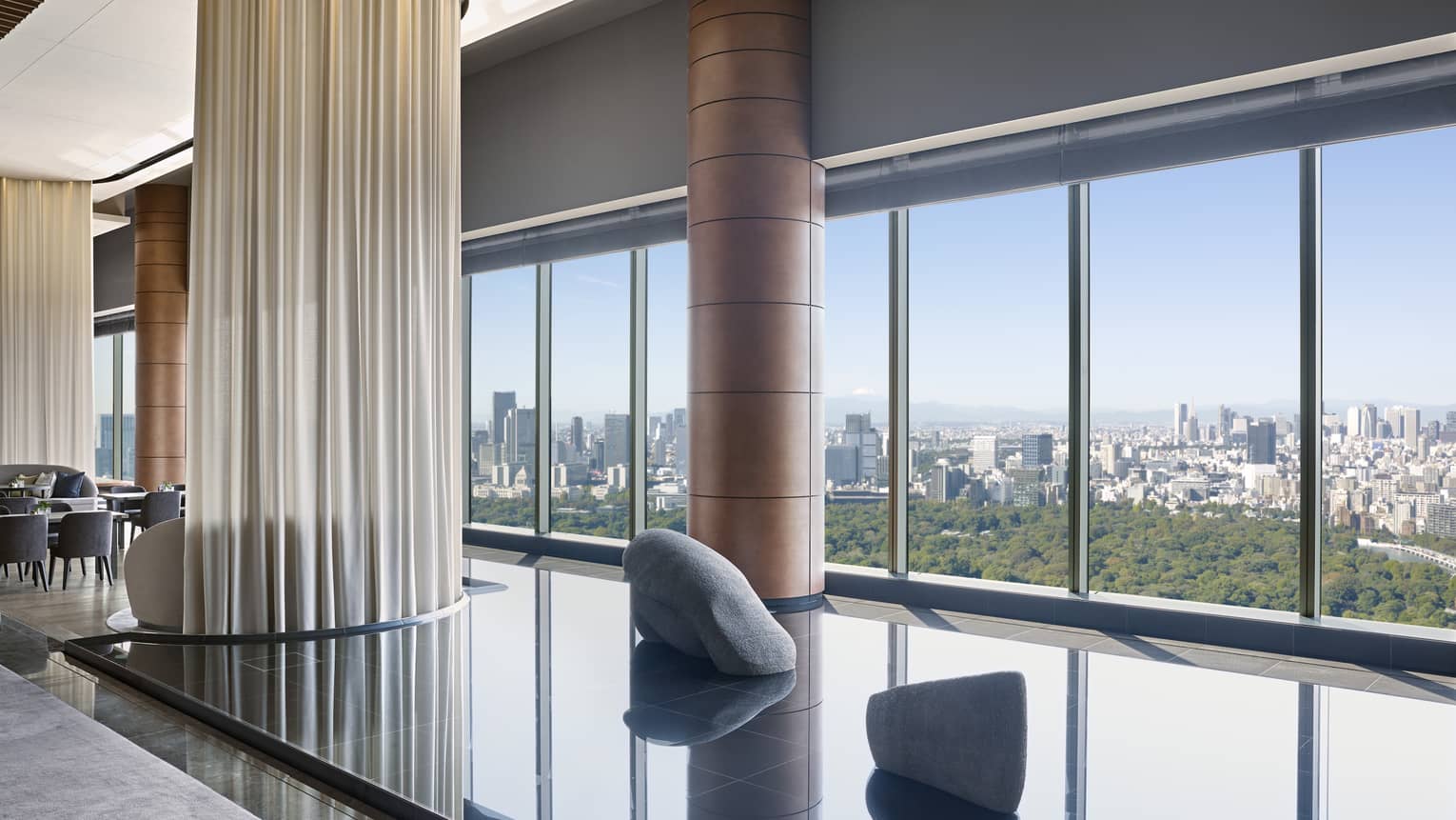 Hotel lounge featuring a calming indoor pond installation and wall of windows 