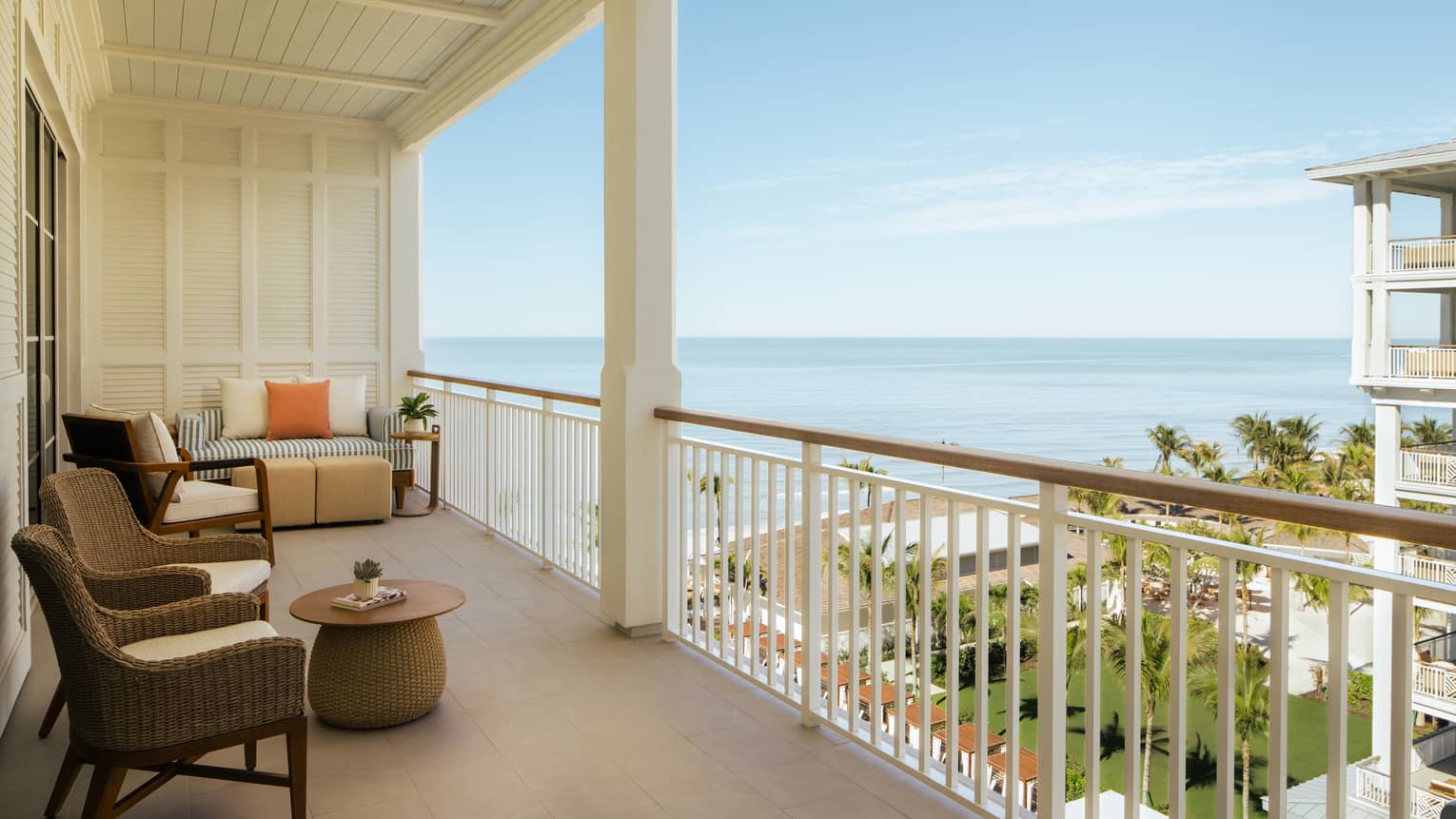 Large private balcony of a resort room, overlooking ocean and resort grounds