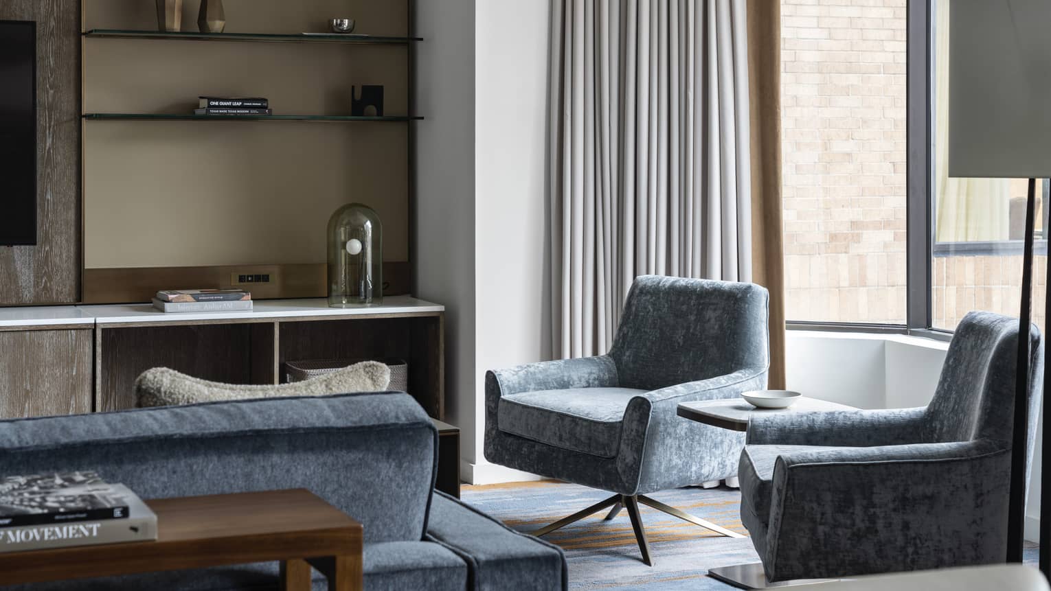 Residence at Four Seasons Hotel Houston, with shelving unit and light-blue chairs and couch near window