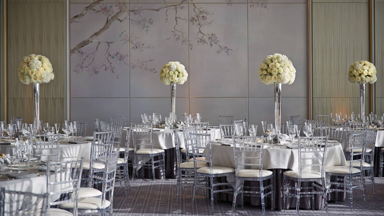 Vinci ballroom banquet dining tables with tall white flowers, accent wall