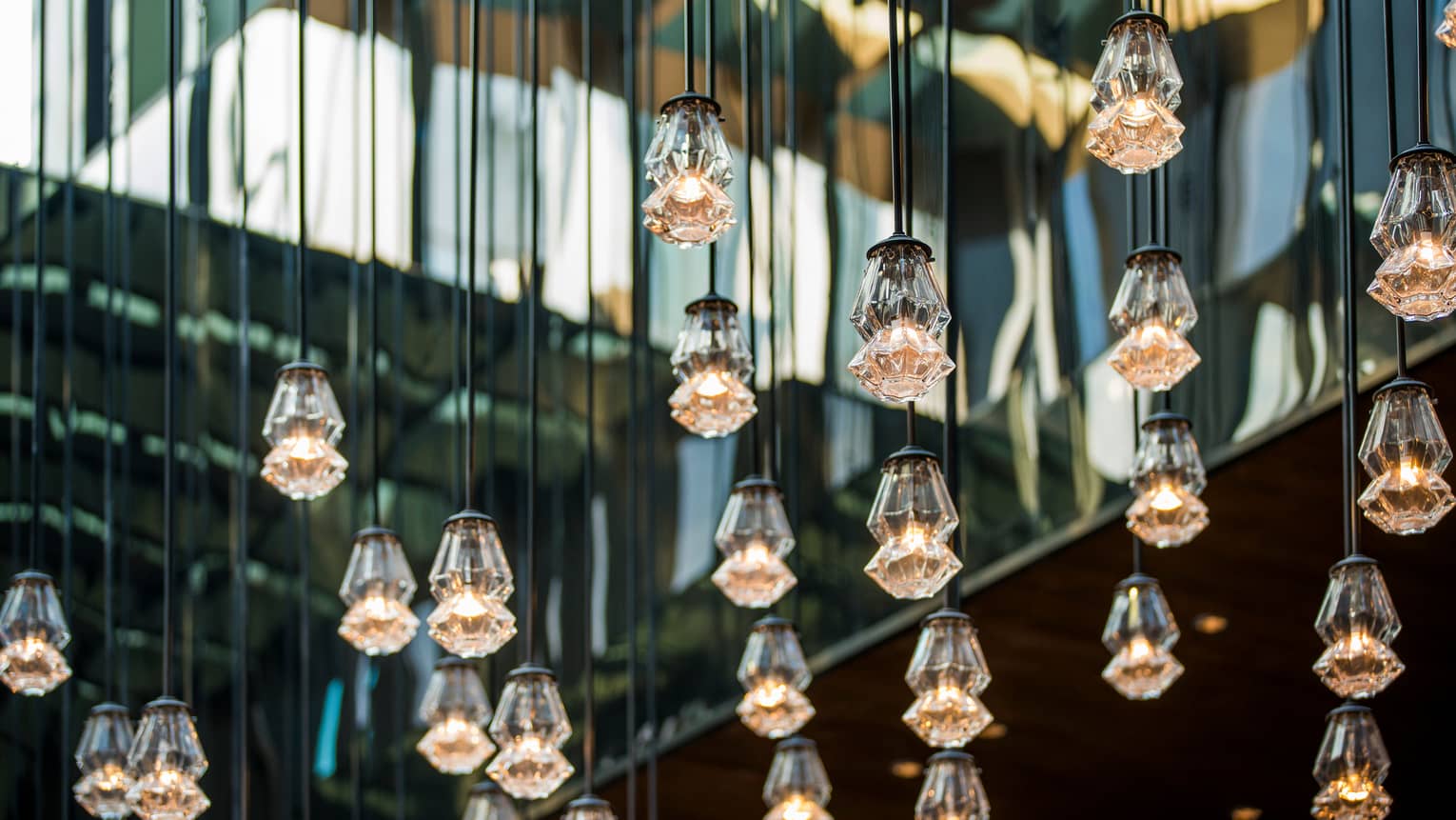 Close-up of dozens of modern crystal lights hanging from strings