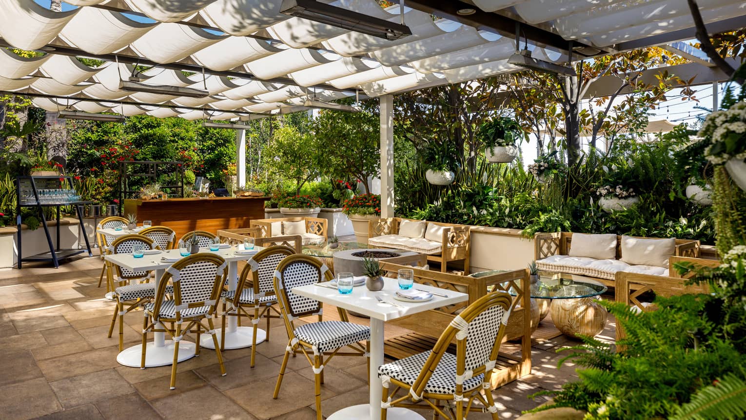 An outdoor covered eating area surrounded by plants.