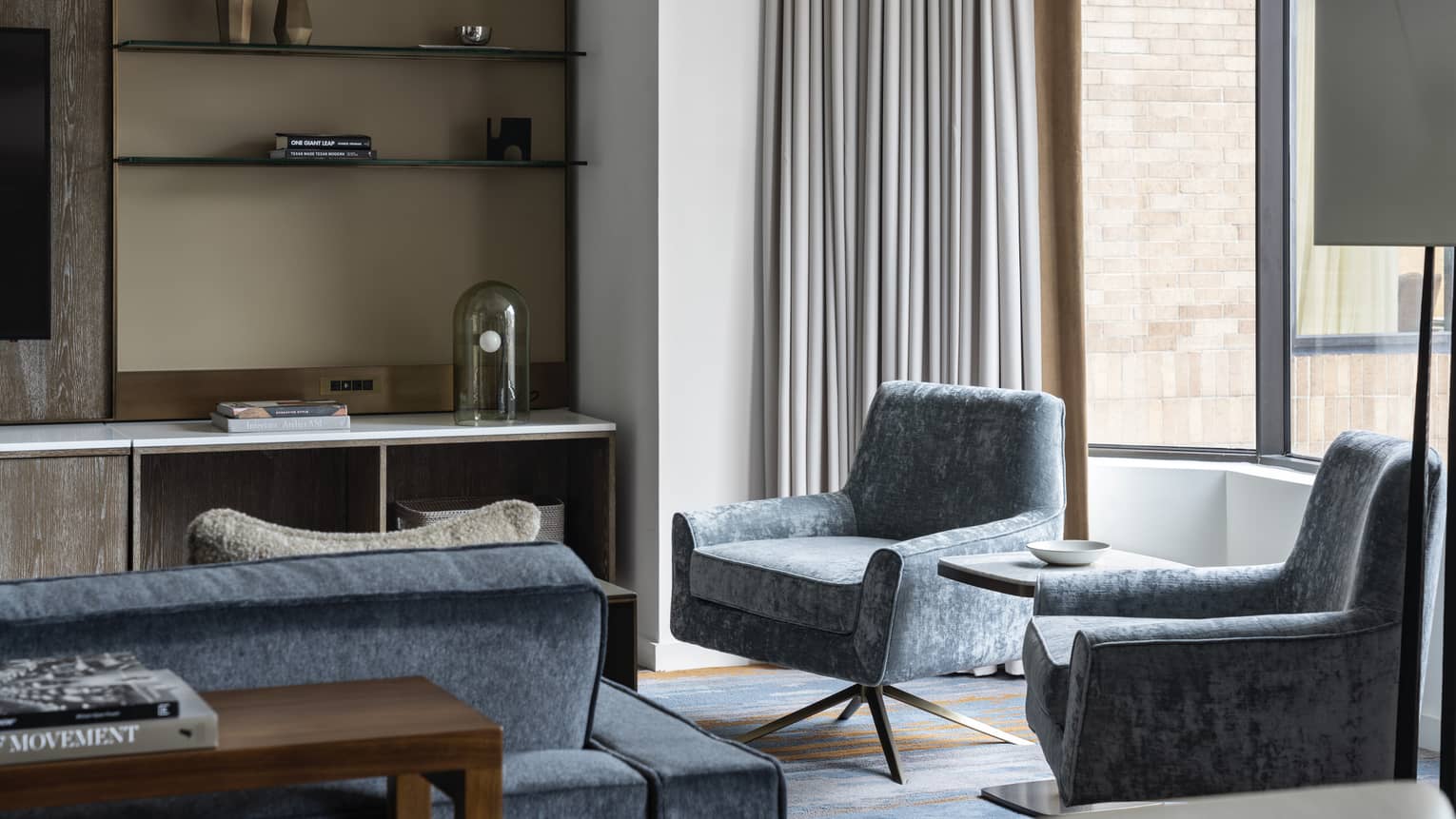 Residence at Four Seasons Hotel Houston, with shelving unit and light-blue chairs and couch near window
