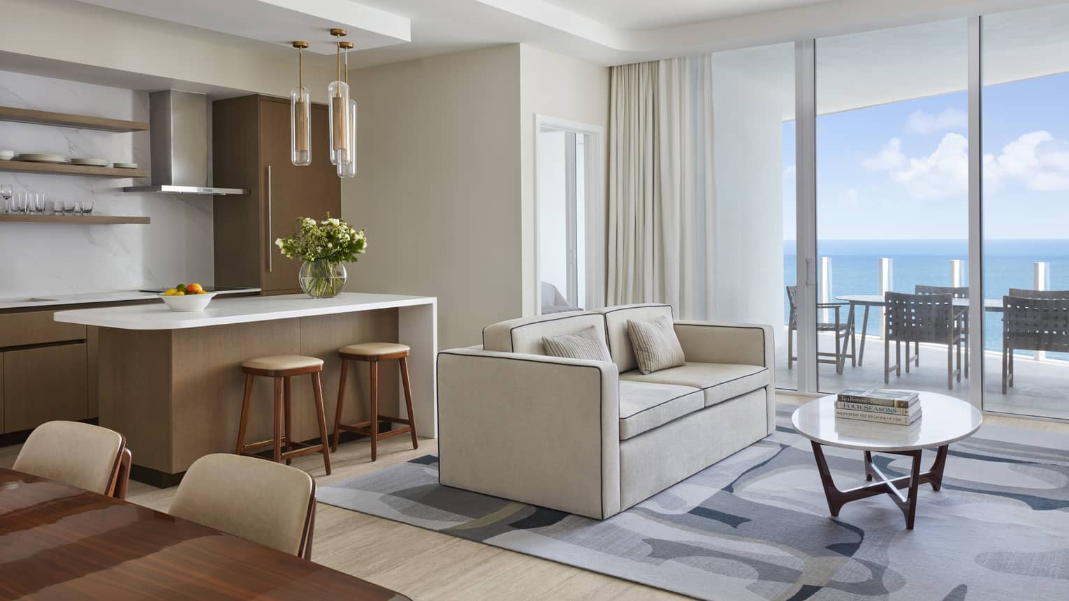 Light-filled living room and kitchen island with ocean view