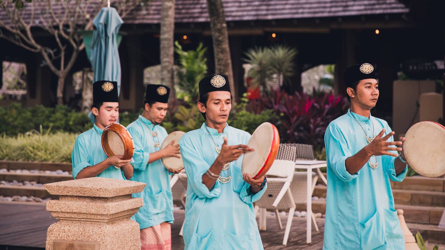 Group of men walk with Kompangs traditional hand drums