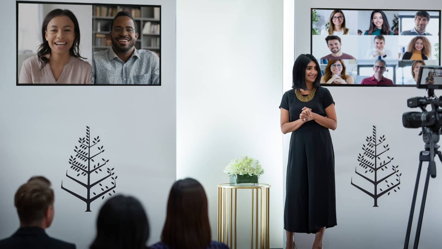 Several people host a virtual meeting in a room with the Four Seasons logo.