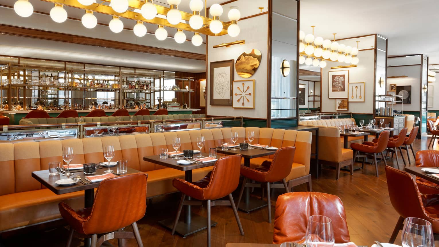 Cafe Boulud orange leather chairs, long banquette under row of globe lights 