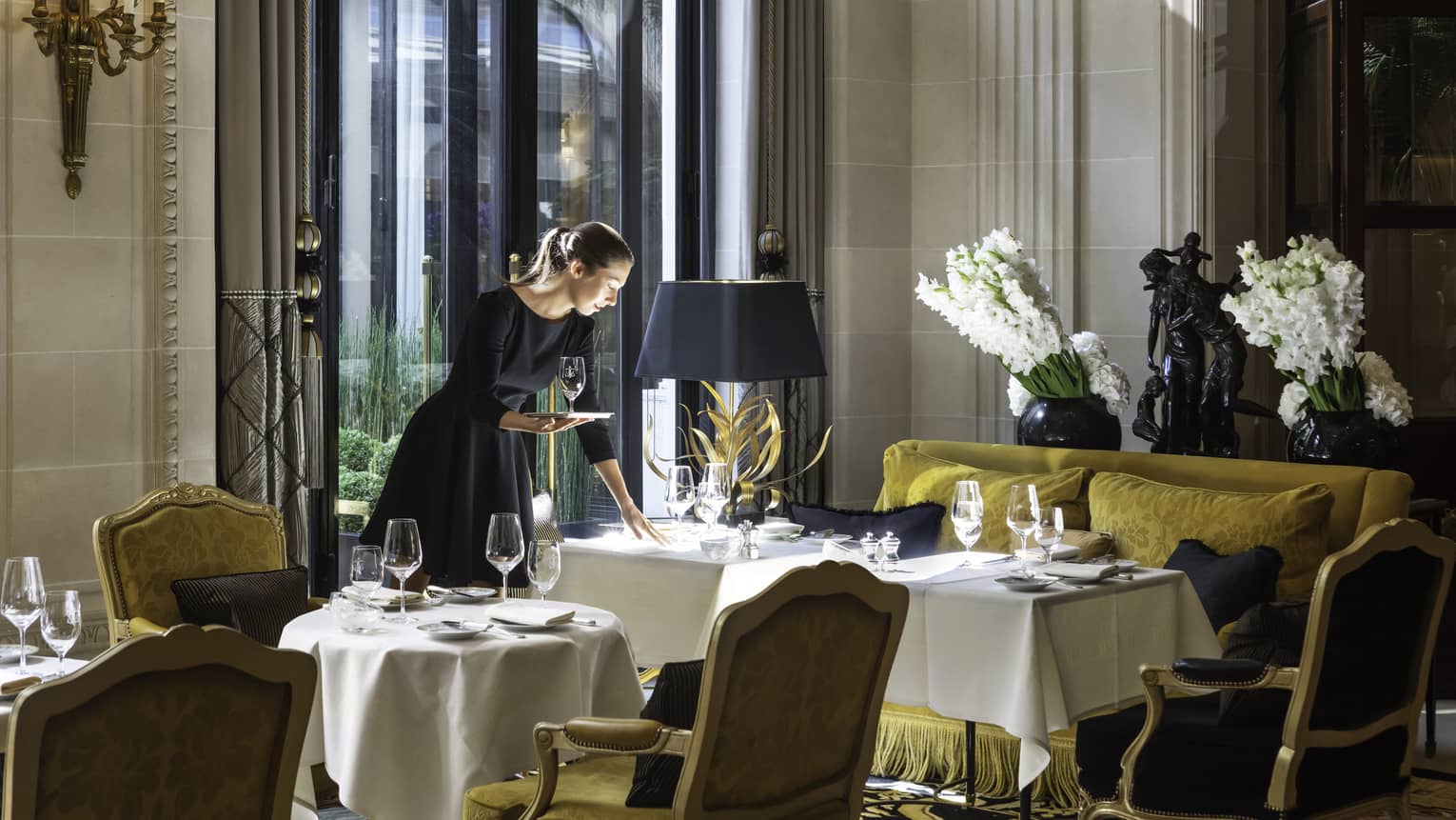 Waitress delivers wine glasses to a table at La Galerie