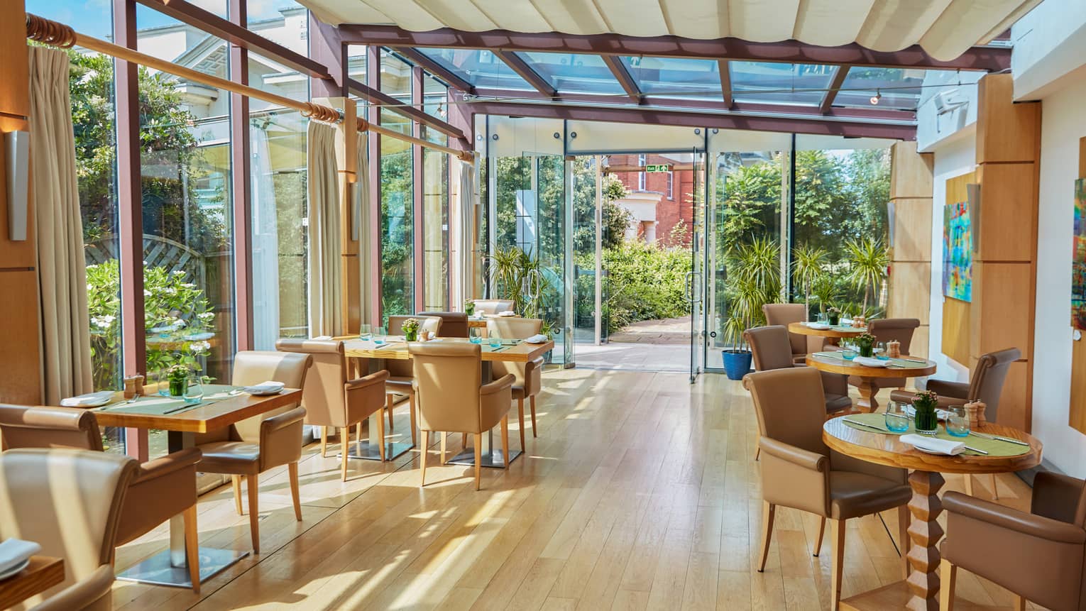 Light-filled restaurant with hardwood floors and brown leather chairs