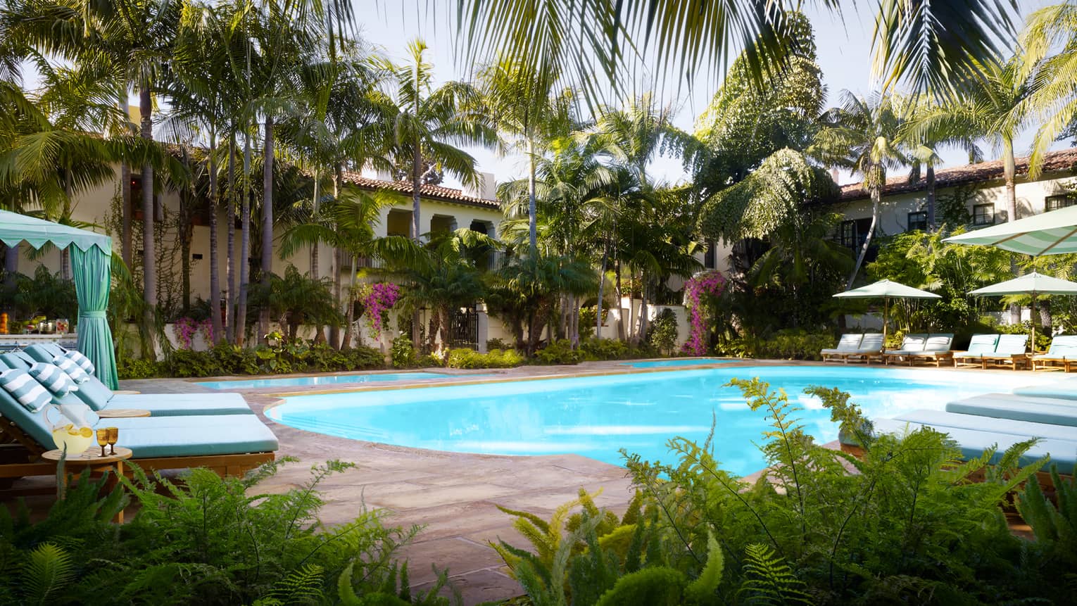 Tropical trees, plants, lounge chairs and cabanas around Jungle Pool