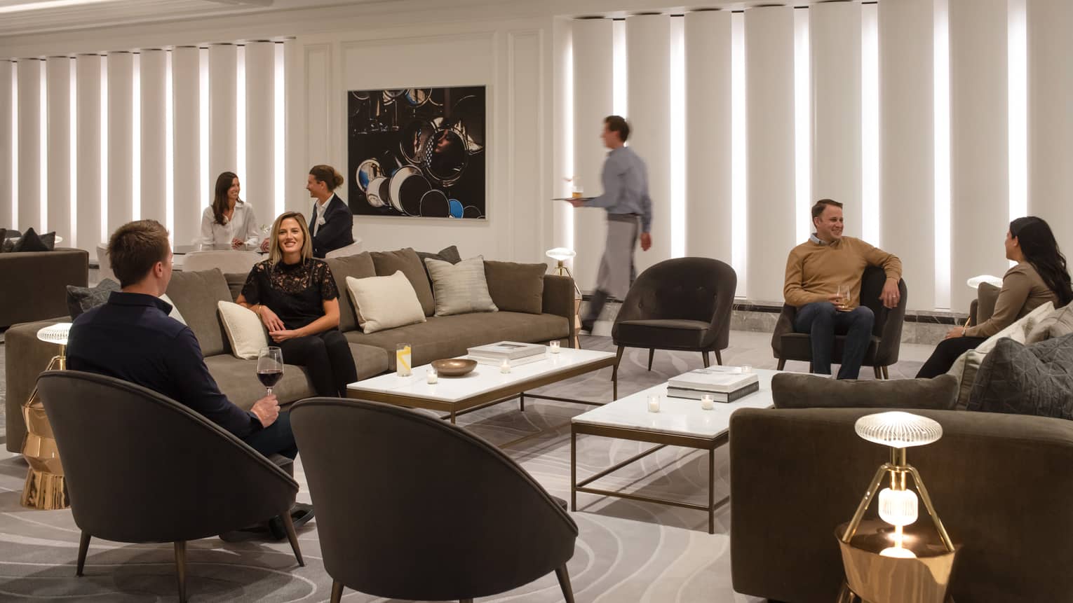 A group of people sitting and chatting in a lounge area.