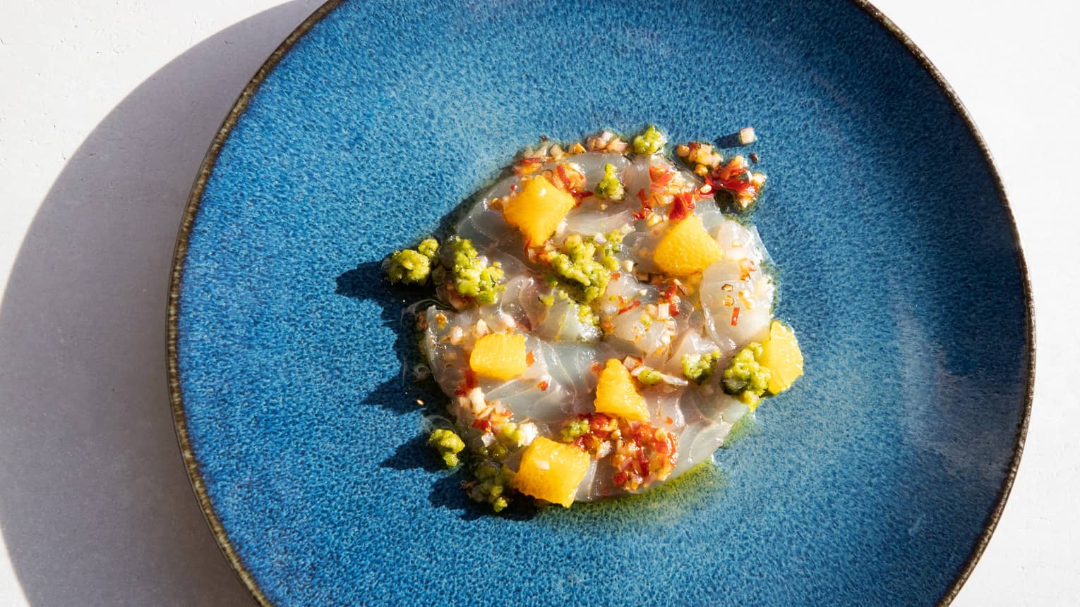 a blue plate with brightly coloured food on it.