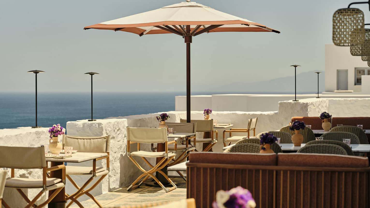 Greek coffee house-bar terrace with umbrellas, overlooking the sea