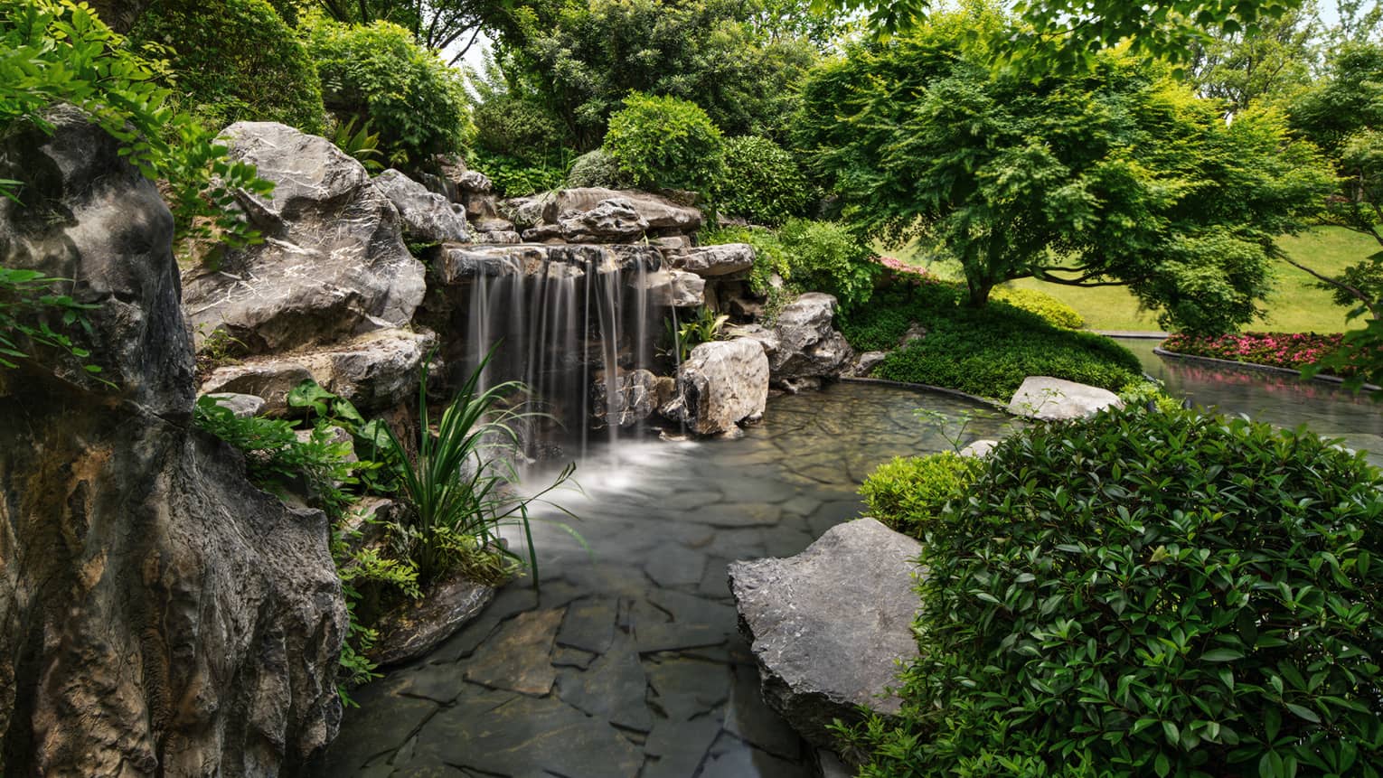 Gardens with waterfall feature at luxury hotel