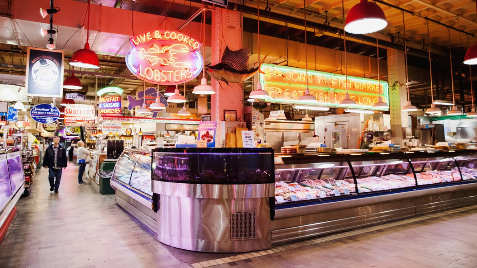 A large indoor market featuring fresh seafood behind glass windows.