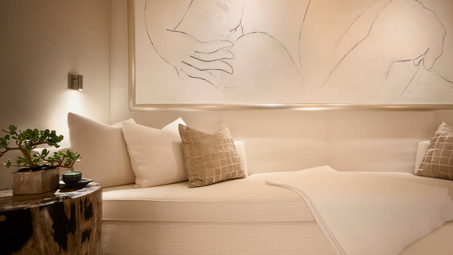 Plush white spa sofa with cushions on large framed print