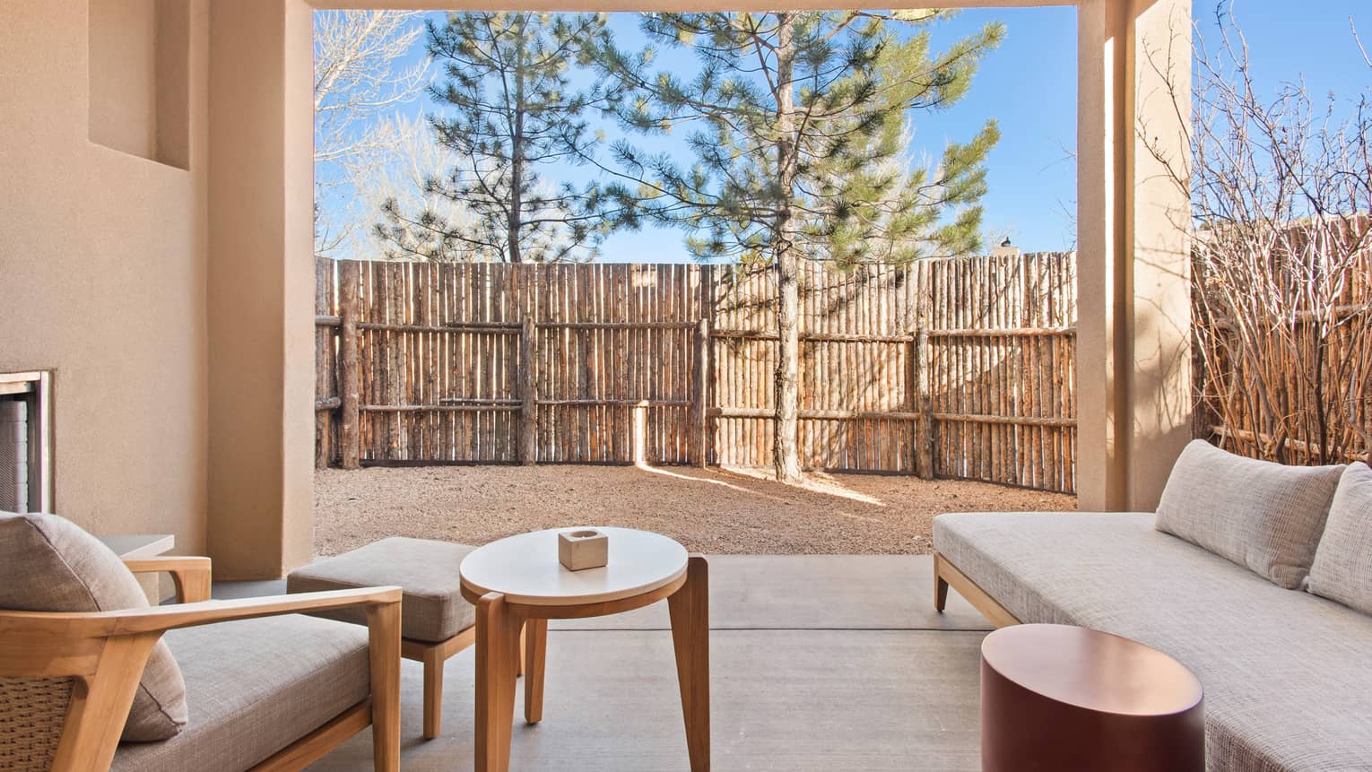 Private patio of a Casita Room, complete with fireplace and lounge chairs, at Four Seasons Resort Santa Fe