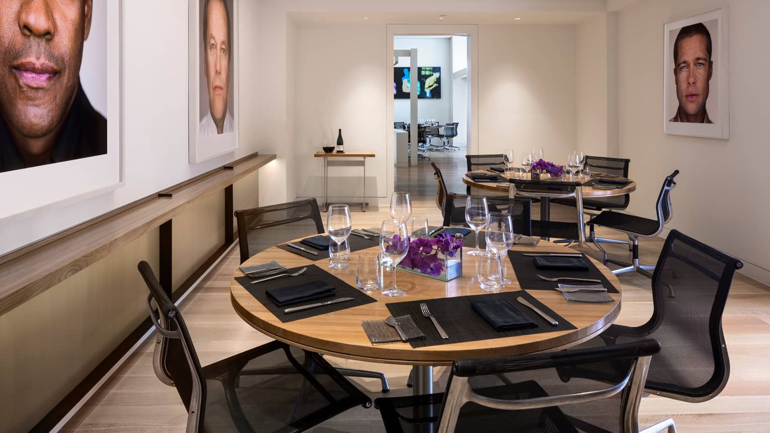 Petit Cut round dining, meeting table under framed prints of Hollywood stars