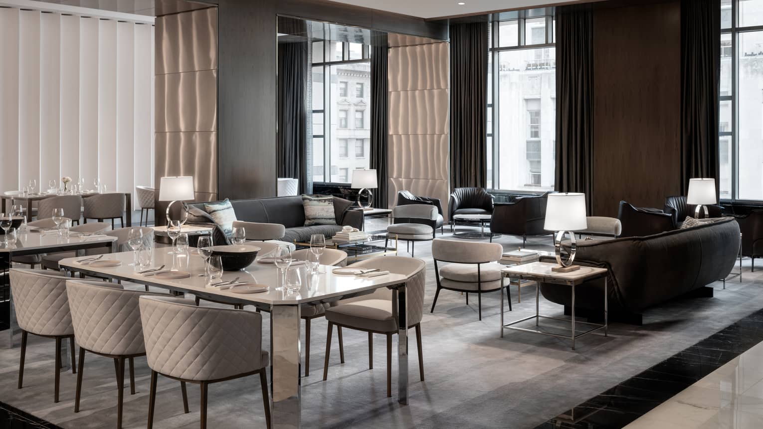 Contemporary restaurant with six-person table and dark leather sofas, tall windows