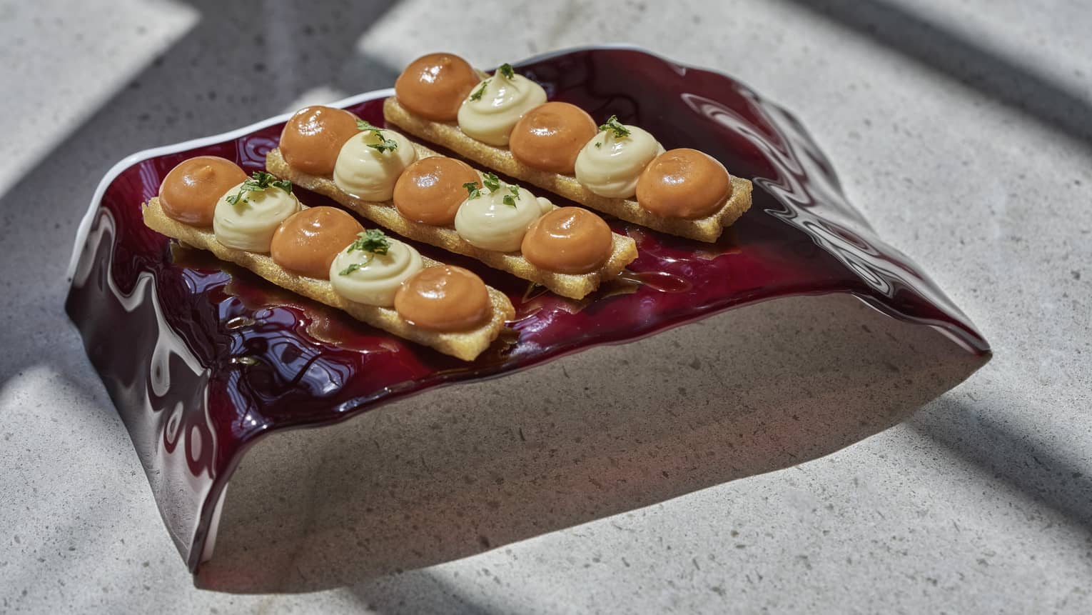 Patatas Bravas with Potato Millefeuille and Spicy Sauce on modern brown plate