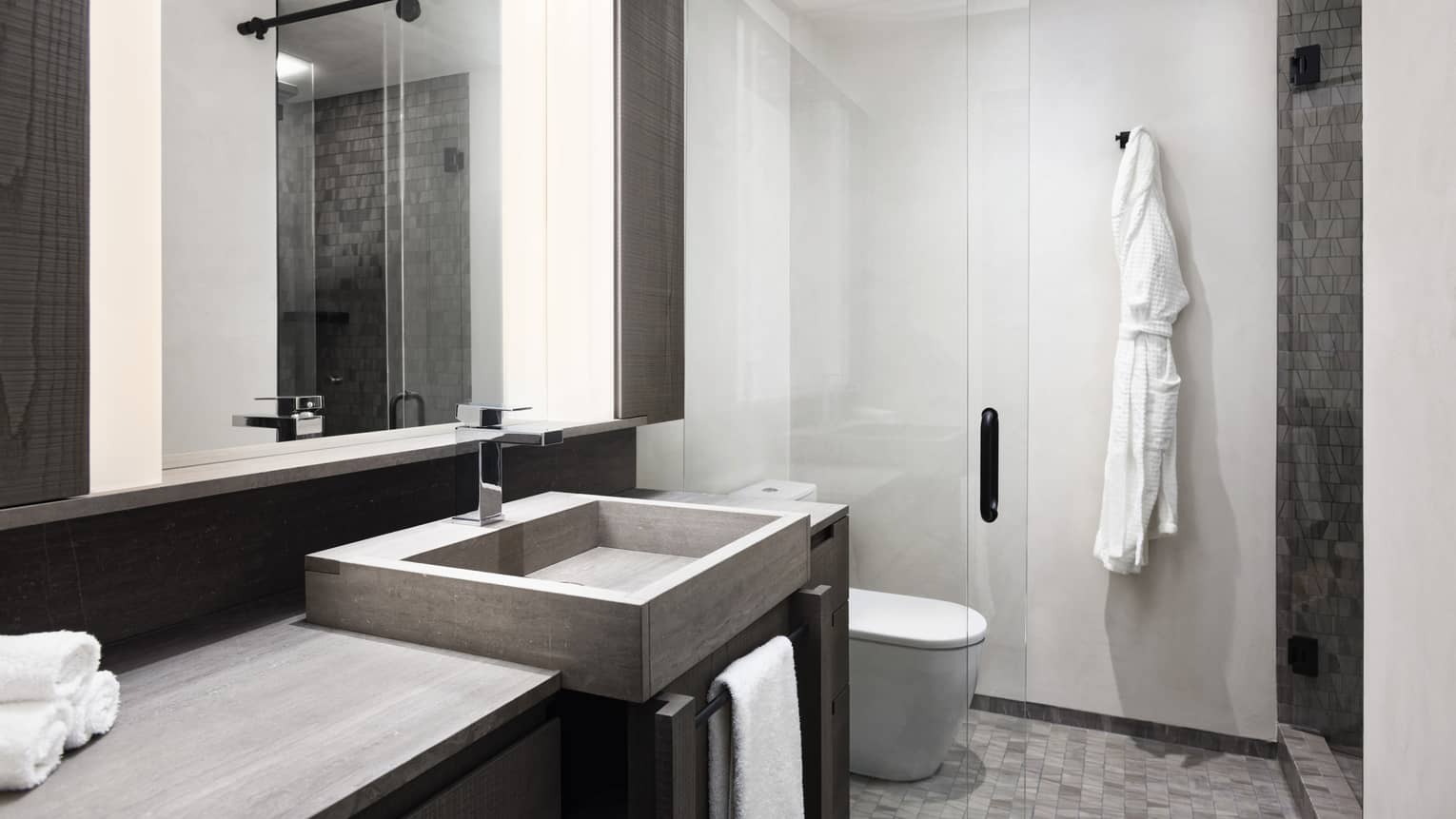 Bathroom with glass shower, stone sink and tile floor