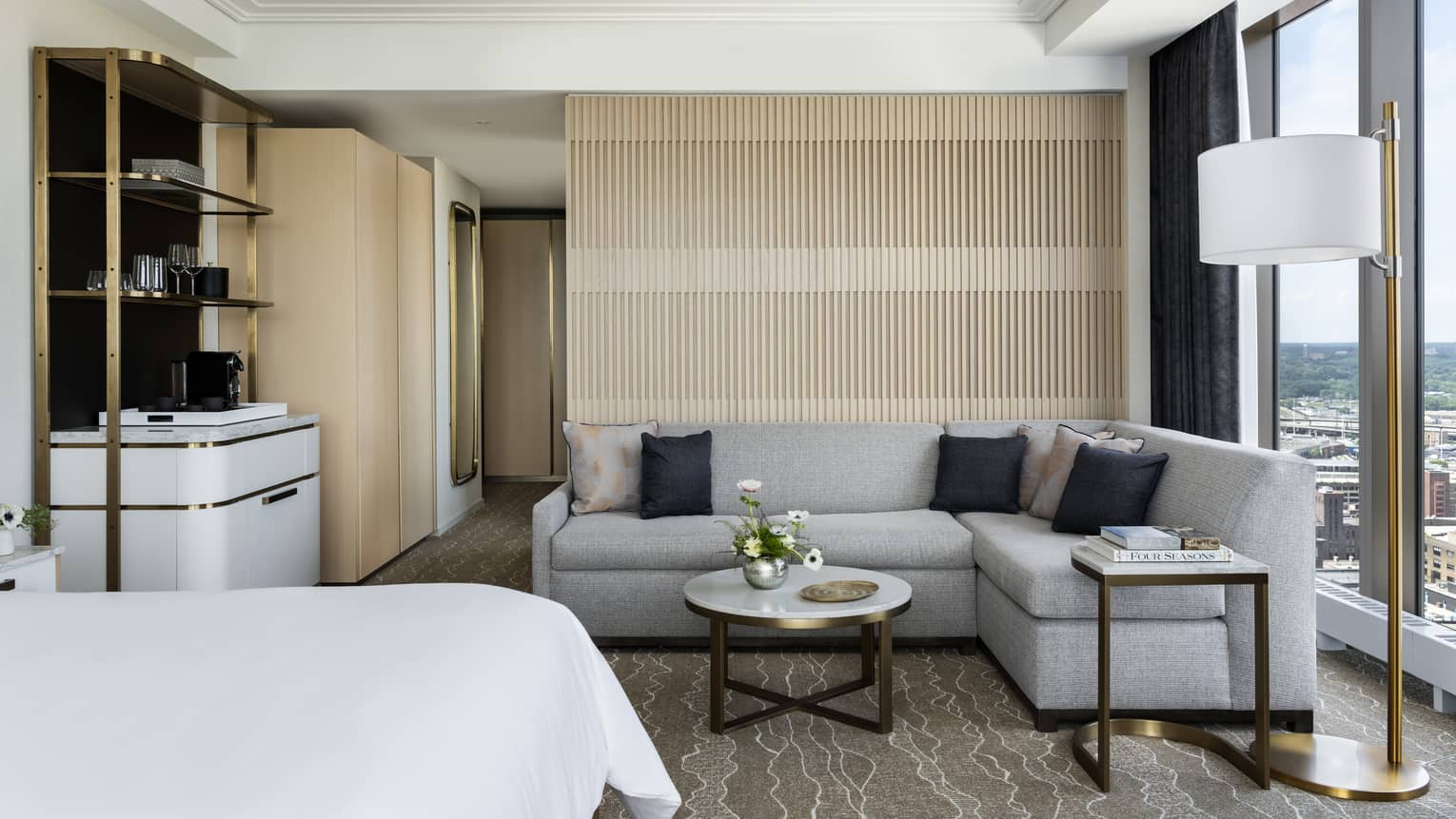 Hotel room with sitting area, complete with a grey sofa and marble coffee table