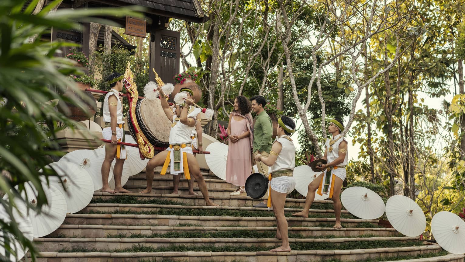 Traditional Lanna dancers perform for a couple on the steps of a temple