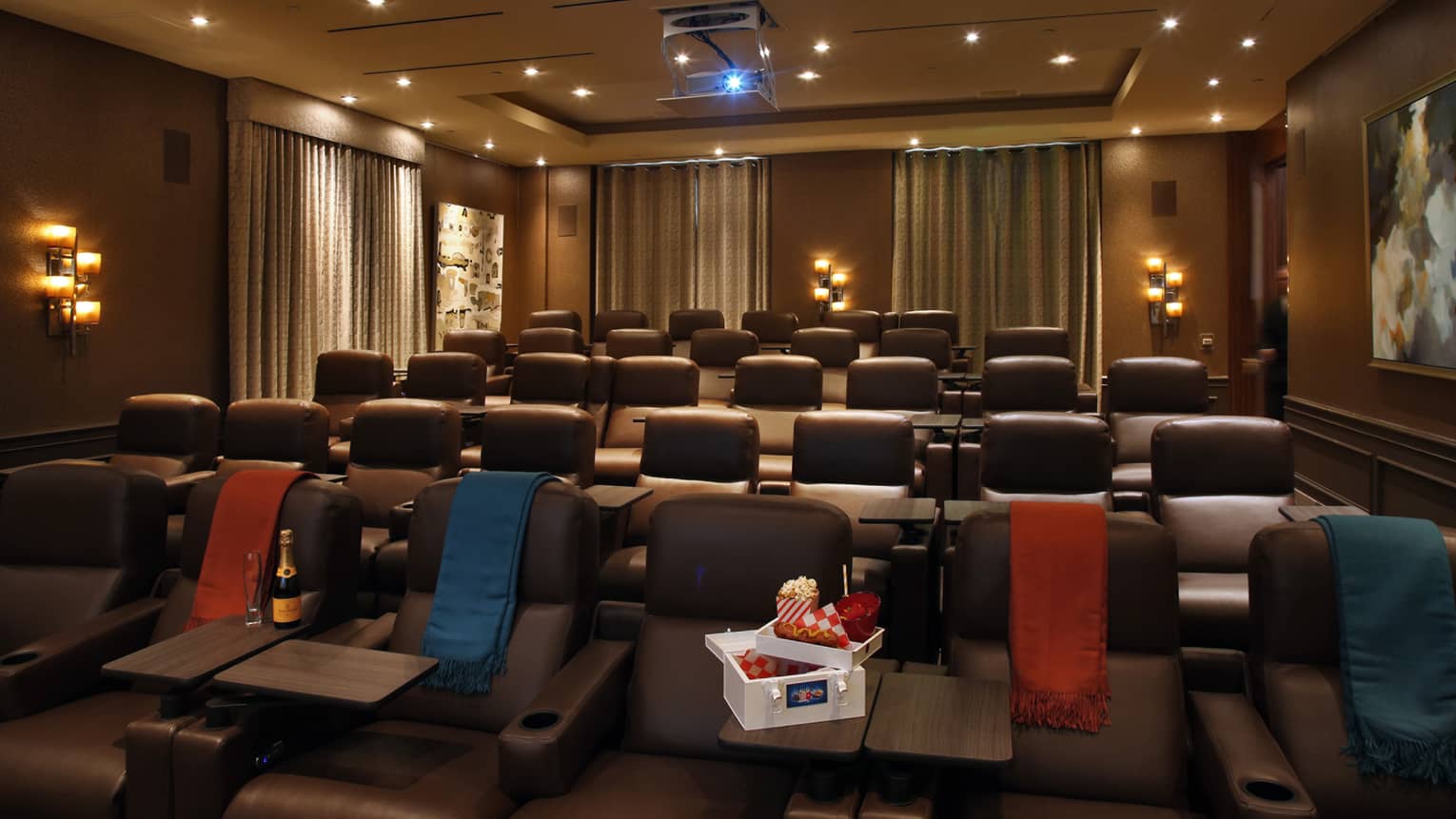 A small movie theatre with a box of snacks in the front row.