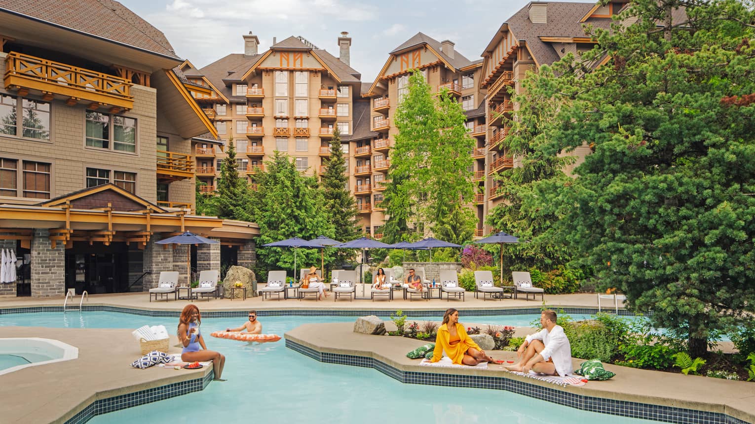 People lounging around an outdoor pool with large hotel buildings in the background.