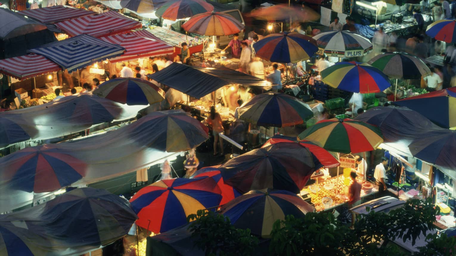 View over Malaysian night market umbrellas, stalls and lights 