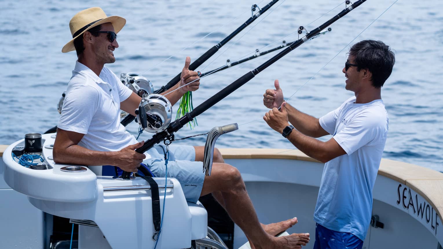 Two men talk on a fishing boat at sea
