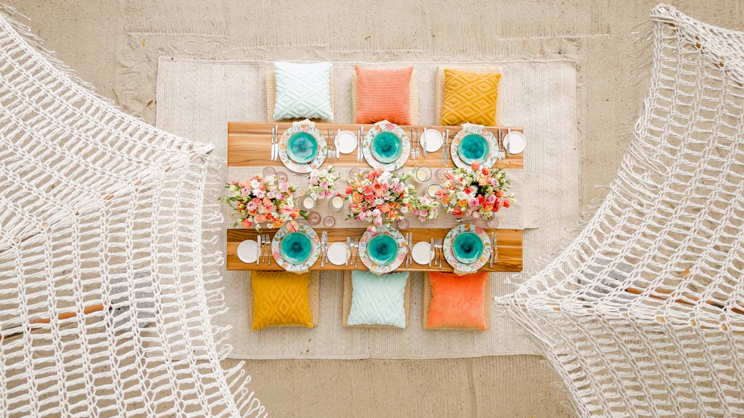 Overhead view of wooden table set up for a private beach meal