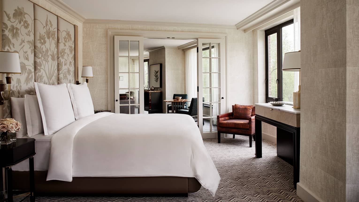 State Suite bedroom with white bed and fabric floral headboard, glass French doors to living room