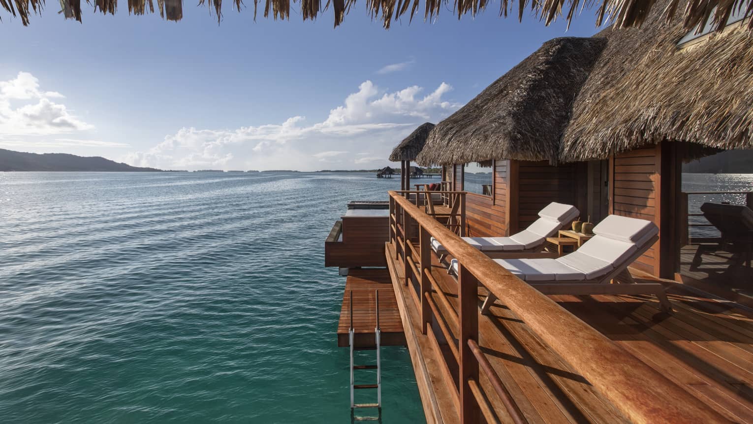Private deck of Bungalow, with two white sun chairs and water views