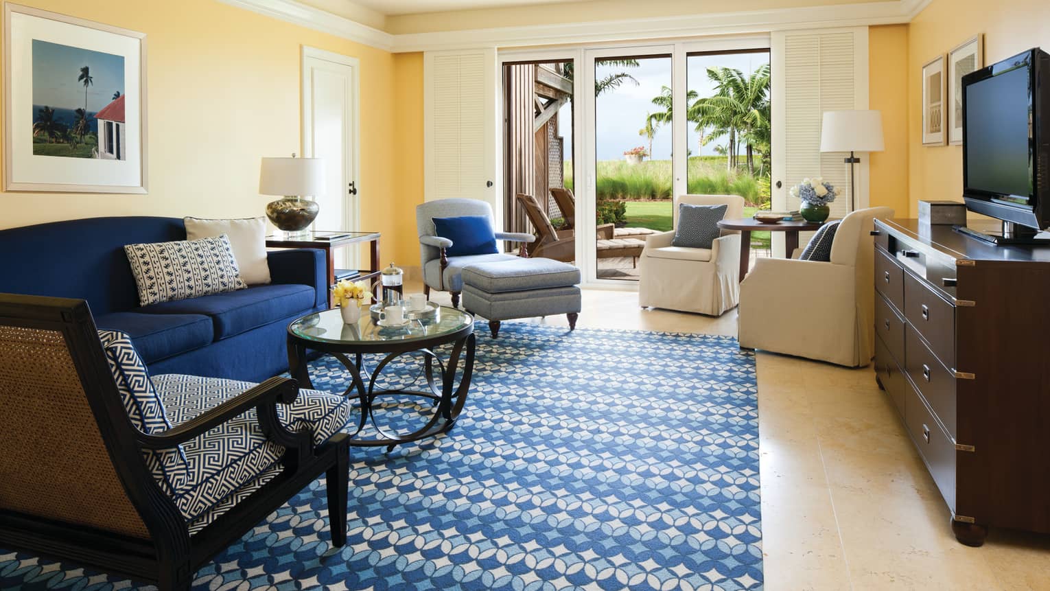 Ocean Suite blue sofa, patterned carpet, armchairs by glass balcony doors