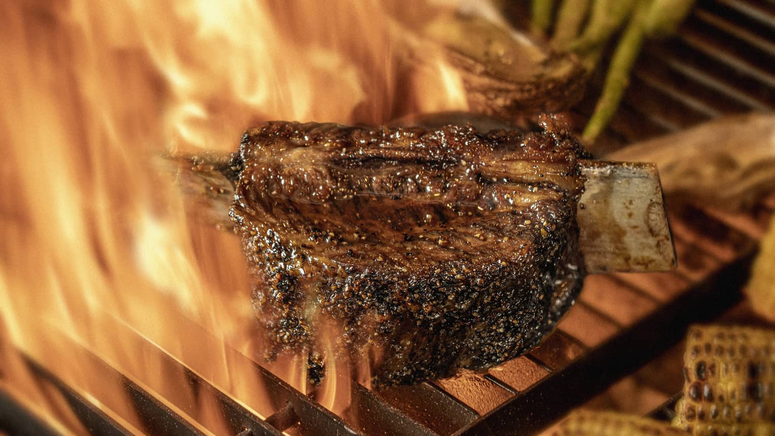 Close-up of chargrilled steak, asparagus and corn on grill grates