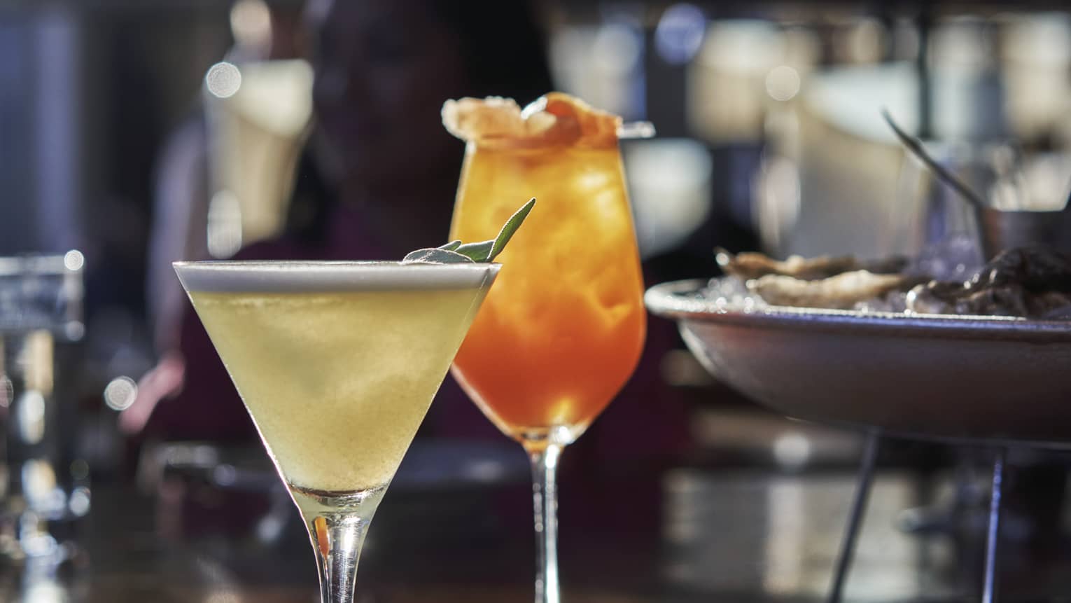 Two colourful, fruity cocktails on bar