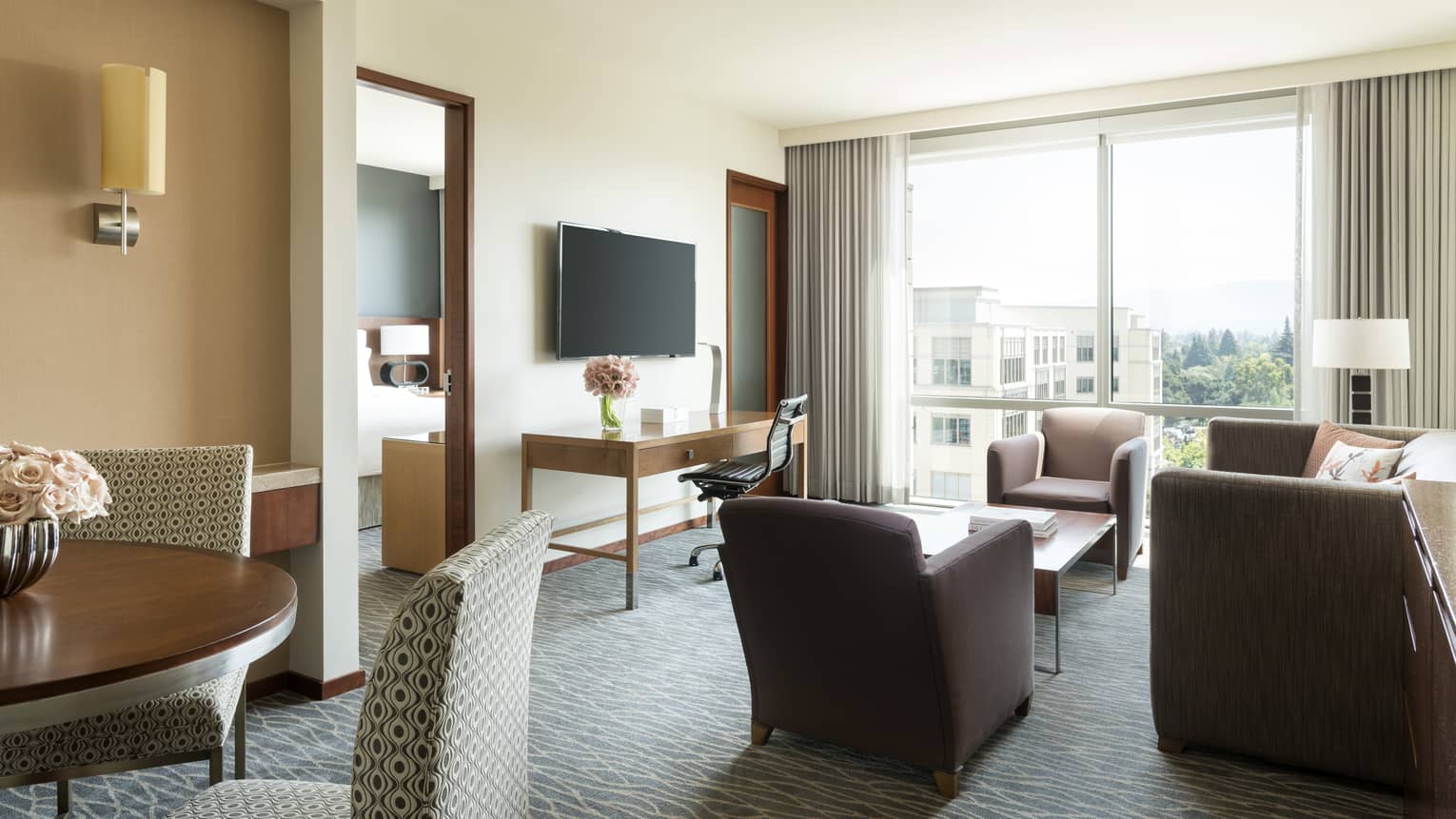 Silicon Valley Suite sunny seating area, dining table, TV, door to bedroom