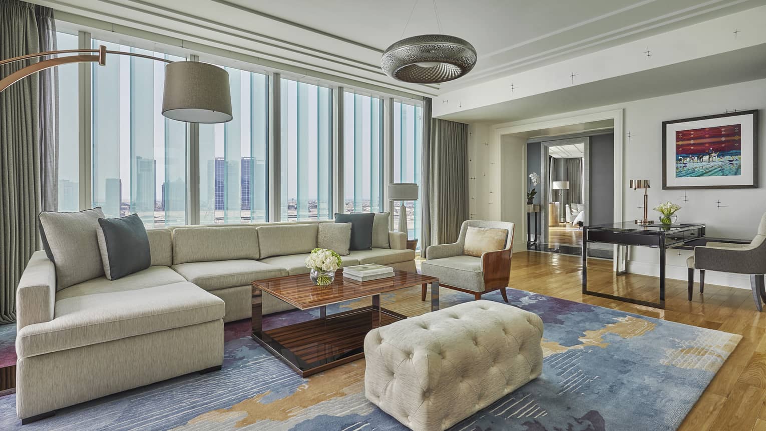 A plush couch sits atop a colourful rug in the Premier King Suite