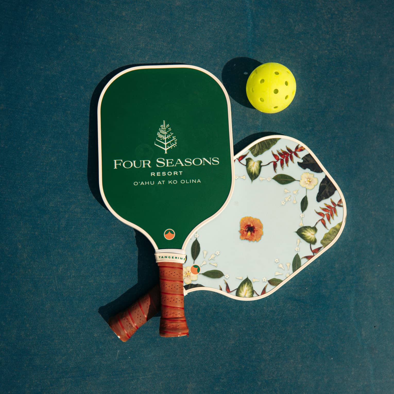 Pickleball paddles with Four Seasons Resort logo, and a yellow ball