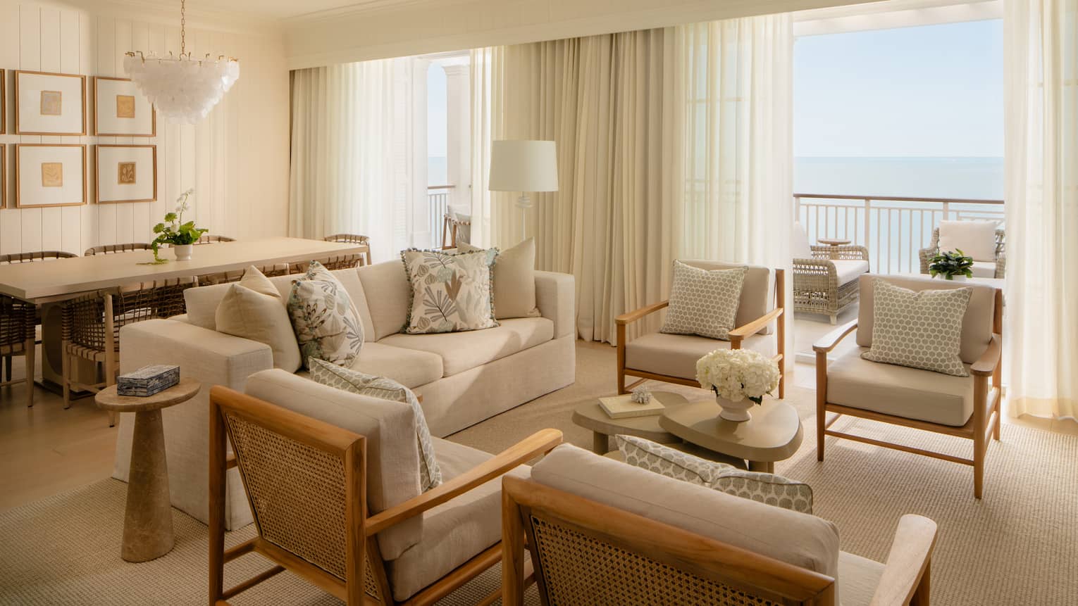 Luxury resort suite featuring a light-filled living room with off-white seating and a dining area