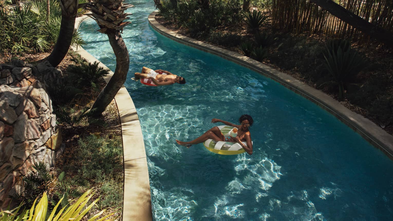 Two guests on floats on the lazy river.