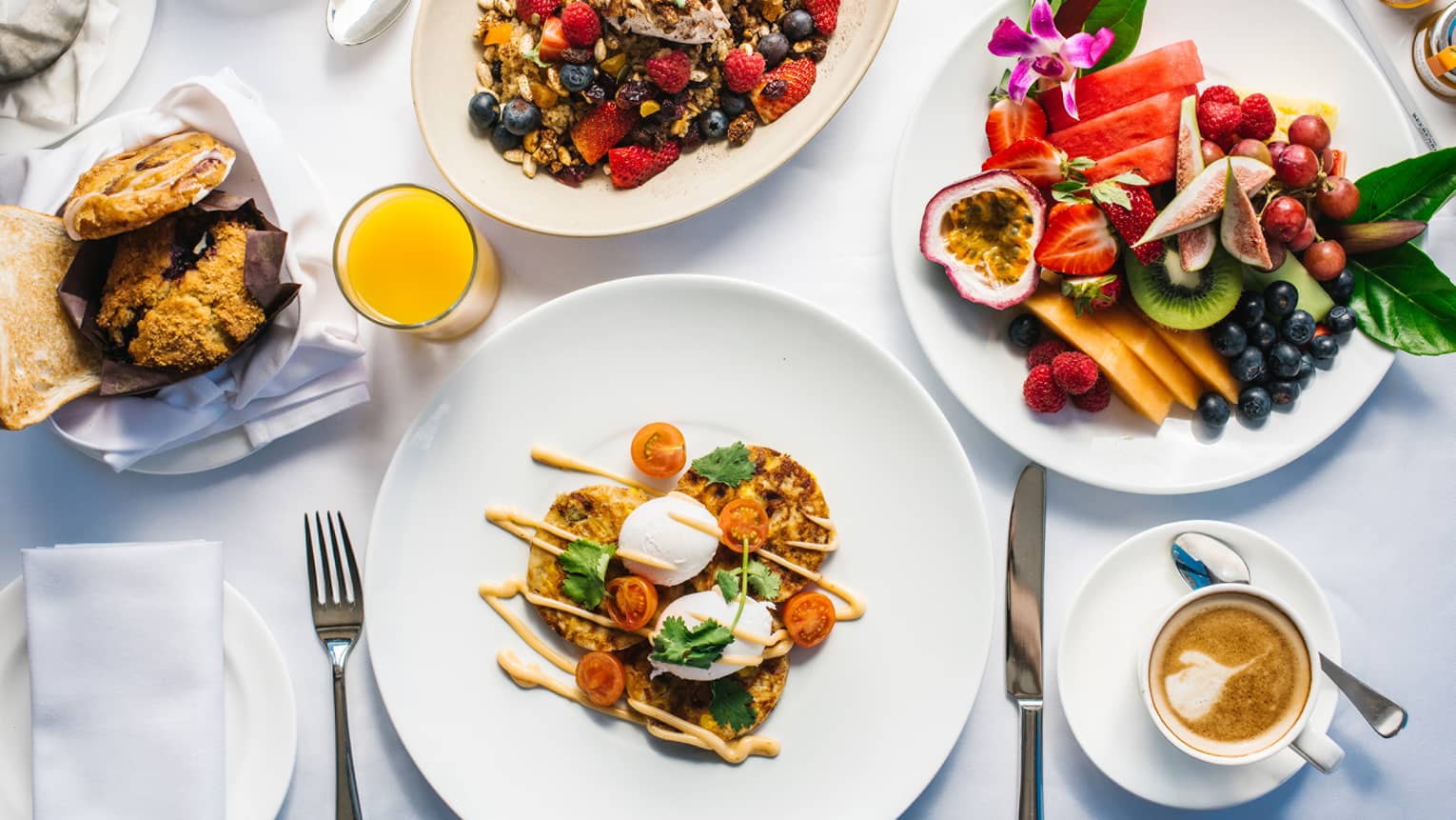 Aerial view of gourmet brunch dishes, fresh fruit platters arranged on table