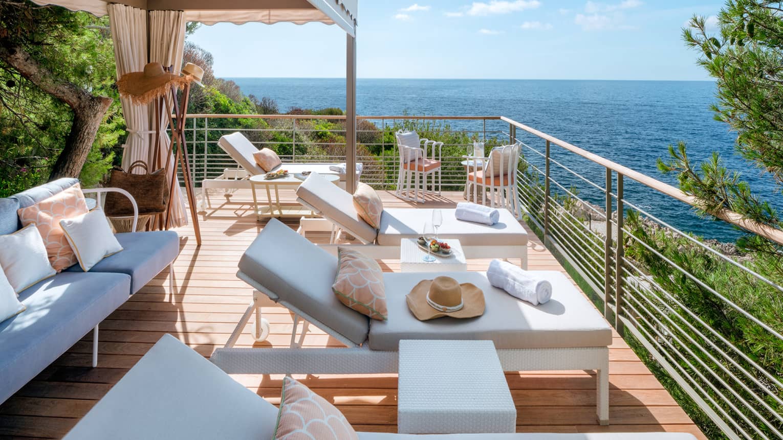 Club Dauphin private cabana terrace with white settee and lounge chairs, sea view