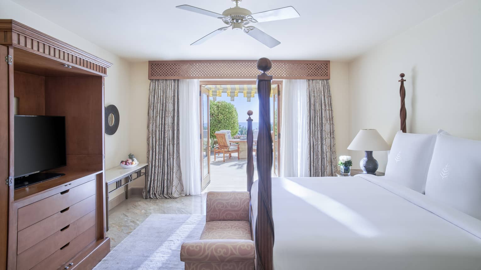 Bedroom with four-poster king bed, dresser, TV and walk-out terrace