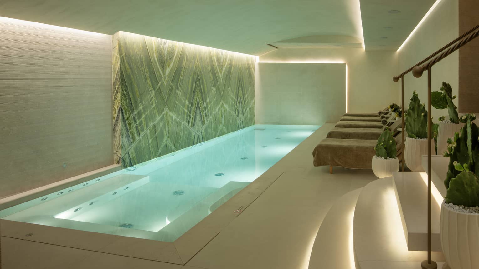 Indoor spa pool with uplit ceiling and steps