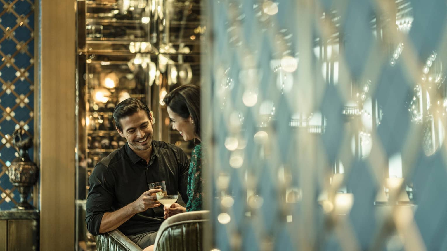 A couple sits together sharing a drink at a restaurant