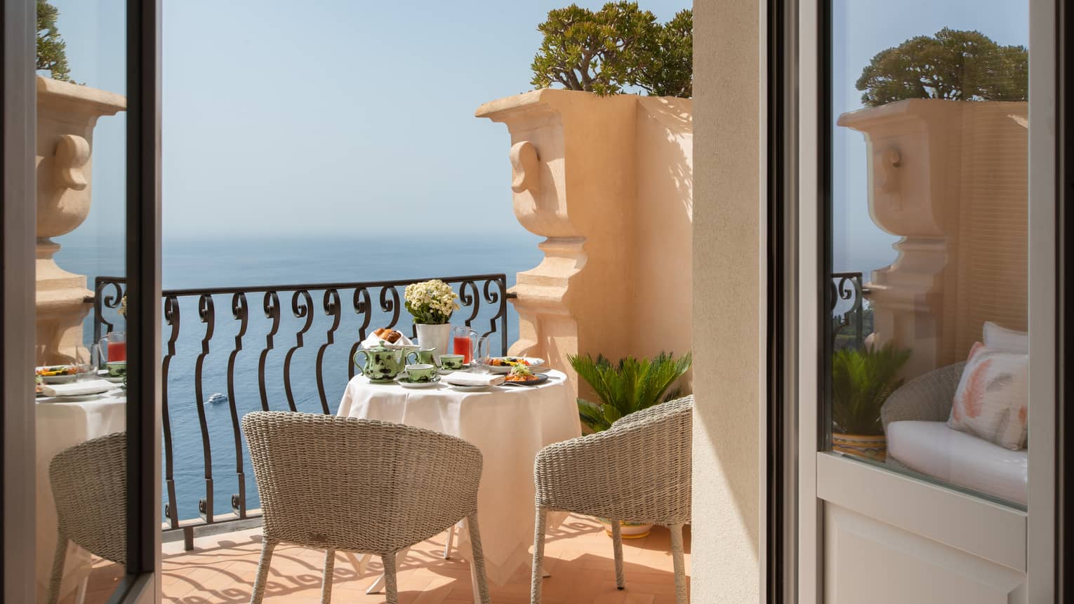 Terrace in-room dining balcony with table set for two, views of the Mediterranean Sea